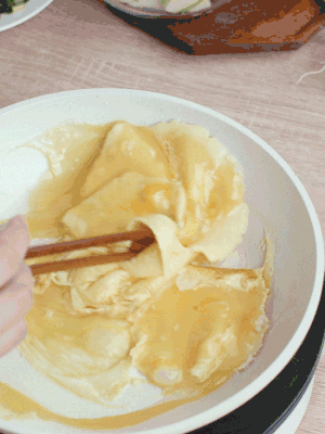 油6成熱時(shí)，下雞蛋液，邊緣凝固時(shí)翻拌成塊狀。