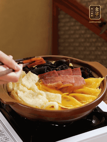 砂鍋底部鋪上娃娃菜，依次擺上肉皮、蛋餃、黑木耳、火腿